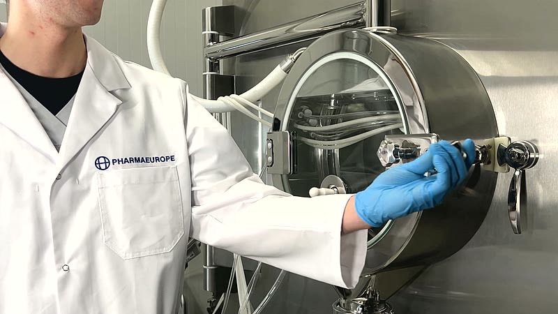 Operator in a PharmaEurope coat at the coating pan